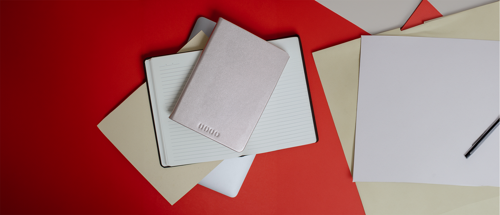 Libreta PRO Rose Gold abierta sobre fondo rojo
